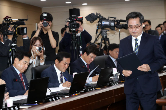 18일 정부세종청사에서 열린 기획재정위원회의 기획재정부 국정감사에서 김동연 경제부총리 겸 기획재정부 장관이 선서를 마친 뒤 정성호 위원장에게 전달하러 가고 있다. 왼쪽은 자유한국당 심재철 의원. 2018.10.18  연합뉴스
