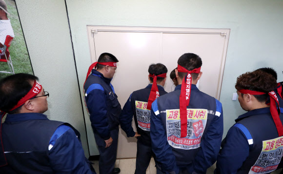 한국지엠(GM) 주주총회가 열리는 19일 오후 주주총회 장소로 알려진 인천시 부평구 한국지엠 부평공장 본사 사장실 주 통로 앞에서 전국금속노동조합 한국GM지부 노조원들이 출입을 시도하고 있다.  한국GM은 이날 주주총회를 소집해 글로벌 제품 연구개발을 전담할 신설 법인 설립 안건을 통과시킬 예정이, 한국지엠 노조원들은 이를 저지할 계획이다. 2018.10.19  연합뉴스