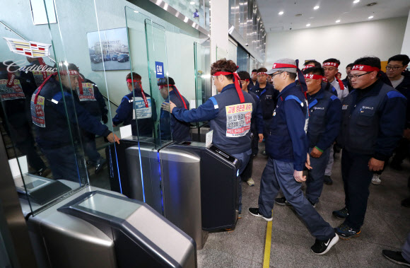 한국지엠(GM) 주주총회가 열리는 19일 오후 전국금속노동조합 한국지엠지부 노조원들이 주주총회 장소로 알려진 인천시 부평구 한국지엠 부평공장 본사 건물 내부로 들어서고 있다.  한국지엠은 이날 주주총회를 소집해 글로벌 제품 연구개발을 전담할 신설 법인 설립 안건을 통과시킬 예정이며, 한국지엠 노조원들은 이를 저지할 계획이다. 2018.10.19  연합뉴스