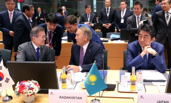 문재인 대통령이 19일(현지시간) 오전 벨기에 브뤼셀 유러피언빌딩에서 열린 제12차 아셈정상회의 전체회의에 참석해 누르술탄 나자르바예프 카자흐스탄 대통령과 대화를 나누고 있다. 오른쪽은 아베 신조 일본 총리. 2018.10.19. 2018.10.19  연합뉴스