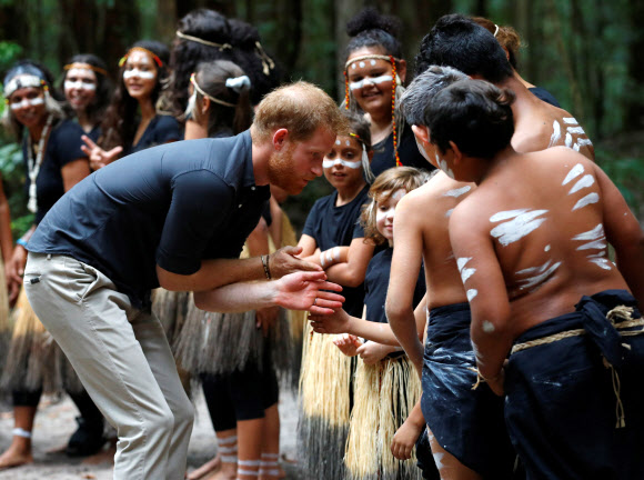 영국의 해리 왕자가 22일(현지시간) 호주 퀸즈랜드 프레이저 아일랜드에서 원주민들과 악수를 나누고 있다. 로이터 연합뉴스