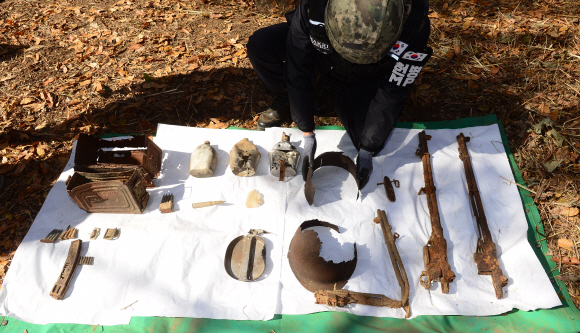 25일 오전 강원도 철원군 철원읍 백마고지 인근 화살머리고지에서 국방부 유해발굴감식단원이 함께 발굴된  6.25 당시 전투 장비를 보여주고 있다. 2018. 10. 25 사진공동취재단