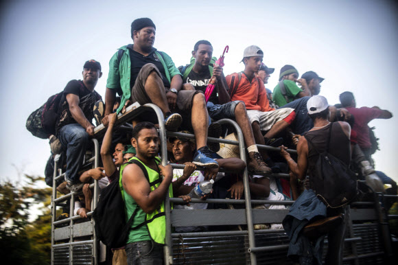 Honduran migrants heading in a caravan to the US, travel aboard a truck near Mapastepec, Chiapas state, Mexico, on October 25, 2018. - Thousands of Central American migrants crossing Mexico toward the United States in a caravan have resumed their long trek, walking about 12 hours to their next destination. (Photo by PEDRO PARDO / AFP)/2018-10-26 18:14:51/ <연합뉴스