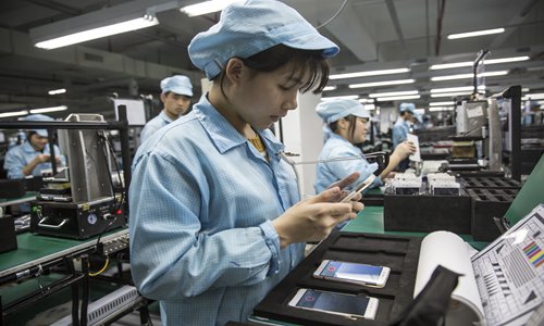 중국 광둥성 동관에 있는 원플러스 공장에서 조립 라인의 직원이 휴대전화를 들여다 보고 있다. 출처:글로벌타임스