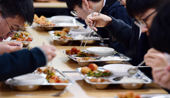 서울의 한 고등학교 학생들이 29일 점심시간에 급식을 먹고 있다. 이 학교는 학부모가 끼니당 4100원가량의 급식비를 내는데 서울시와 서울교육청의 고교 무상급식 정책에 따라 2021년부터는 자부담 없이 급식이 제공될 전망이다.  정연호 기자 tpgod@seoul.co.kr