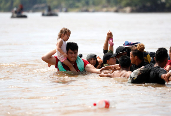 인간띠 의지해 강 건너는 이민자들 