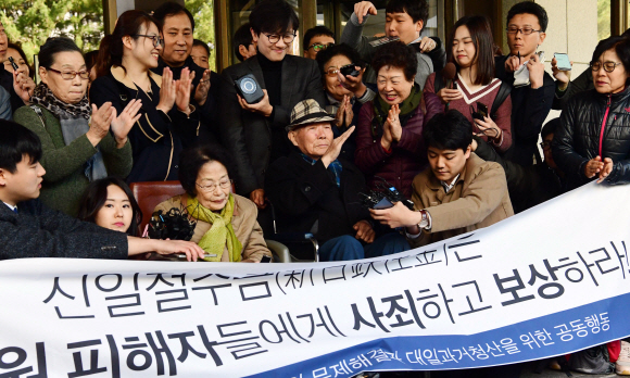 일제 강제징용 피해 생존자인 이춘식(가운데)씨가 30일 일본 기업 상대 강제징용 손해배상청구 소송 재상고심에서 승소 판결을 받은 뒤 재판을 함께 지켜본 시민들로부터 축하 인사를 받고 있다. 정연호 기자 tpgod@seoul.co.kr