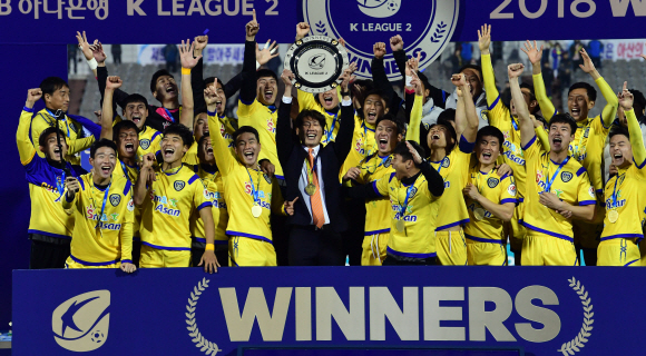 2018 K리그2에서 우승을 차지한 감독과 선수들이 우승트로피를 들어 보이며 세리머니를 하고 있다.