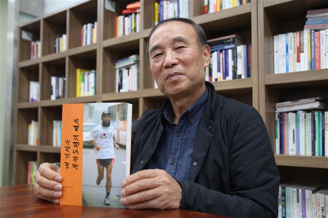 한국에서 월드컵이 열린다는 소식을 알리기 위해 세계를 누볐던 월드컵 마라토너 김홍영씨가 8일 당시를 회고한 자서전을 들어보이며 미소를 짓고 있다.