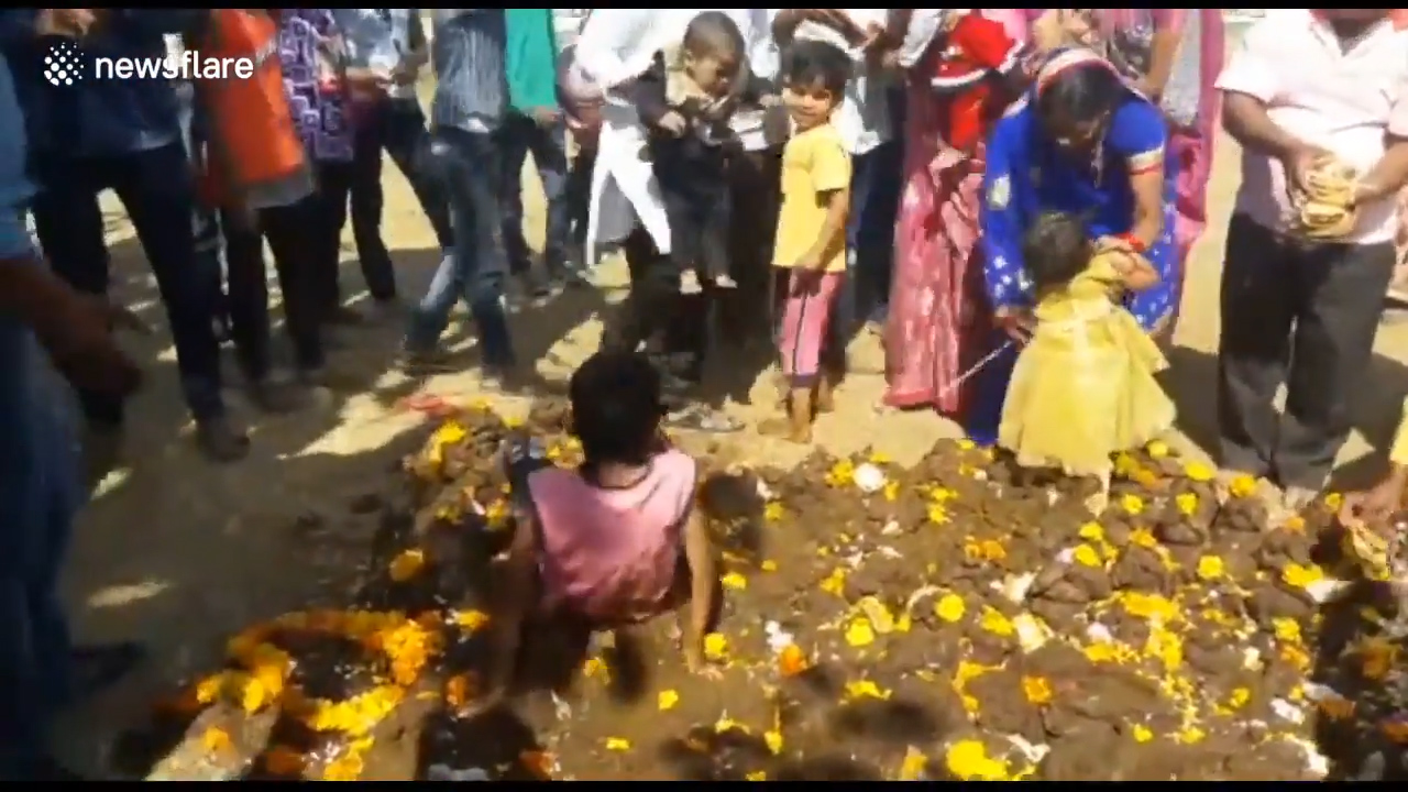 아이의 건강을 위해 소똥 위에 아이를 올려놓은 인도 부모들 모습(유튜브 영상 캡처)