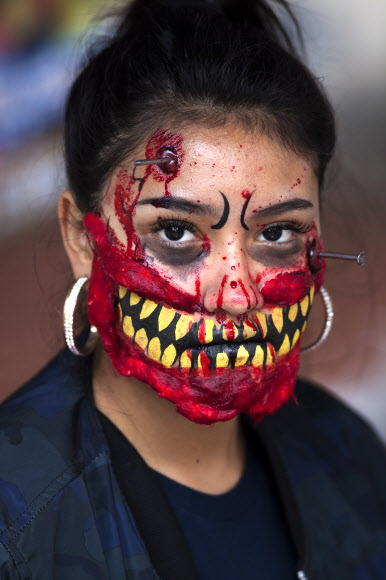 11일(현지시간) 멕시코 멕시코시티에서 열린 ‘좀비 워크’ 에서 분장을 한 여성이 포즈를 취하고 있다. AP 연합뉴스