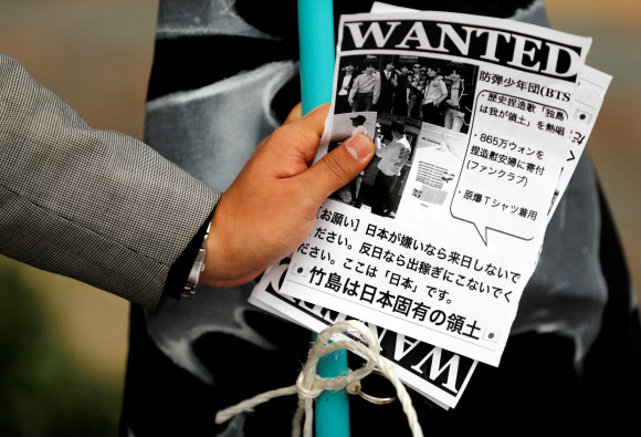 한 남자가 도쿄돔 밖에서 방탄소년단을 비난하는 전단지를 손에 들고 있다. <br>도쿄 로이터 연합뉴스