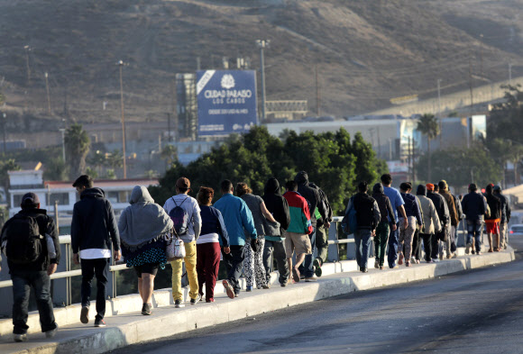 미국 캘리포니아 주 샌디에이고와 국경을 맞닿고 있는 멕시코 티후아나에 도착한 중미 이민자 행렬(캐러밴)이 줄지어 가고 있다. 2018.11.18  AFP 연합뉴스