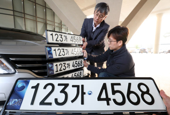 지난 16일 정부세종청사 국토교통부에서 관계자들이 내년 9월부터 변경될 자동차 번호판 선호도 조사를 하고 있다. 신규 발급되는 번호판에는 앞자리 숫자 한자리가 추가된다. 국토부에서는 기존 번호판(위)을 포함한 5개 번호판 디자인 중에서 선호도가 가장 높은 번호판으로 결정할 예정이다. 2018.11.19  연합뉴스
