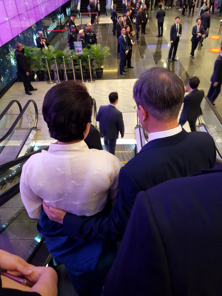 청와대가 문재인 대통령의 싱가포르·파푸아뉴기니 순방 중 수행원들이 휴대전화로 찍은 ‘B컷’을 공개했다. 아세안 회의장으로 이동 중 김정숙 여사를 에스코트하는 문재인 대통령. 청와대 제공