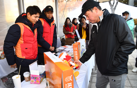 22일 중구  SK 서린빌딩 앞에서 열린 SK 행복나눔 바자회을 찾은 최태원 회장이 판매 물건들을 구매하고 있다 .2018.11.22안주영기자jya@seoul.co.kr