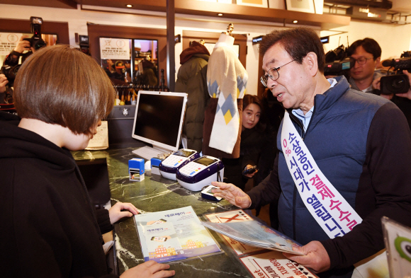 박원순 서울시장이 22일 서울 서대문구 연세로의 한 상점에서 제로페이 홍보를 하고 있다. 소상공인 간편결제 서비스 ‘제로페이’는 소비자가 결제하면 카드사나 VAN사업자 등 중간 결제사를 거치지 않고 소비자 계좌에서 판매자 계좌로 금액이 바로 이체돼 수수료를 줄일 수 있다. 2018. 11. 22. 박윤슬 기자 seul@seoul.co.kr