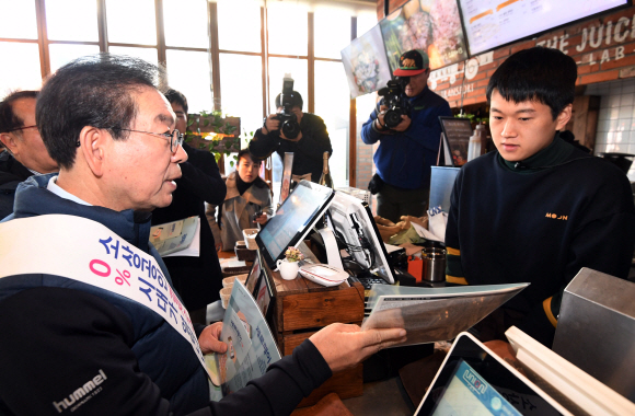 박원순 서울시장이 22일 서울 서대문구 연세로의 한 상점에서 제로페이 홍보를 하고 있다. 소상공인 간편결제 서비스 ‘제로페이’는 소비자가 결제하면 카드사나 VAN사업자 등 중간 결제사를 거치지 않고 소비자 계좌에서 판매자 계좌로 금액이 바로 이체돼 수수료를 줄일 수 있다. 2018. 11. 22. 박윤슬 기자 seul@seoul.co.kr
