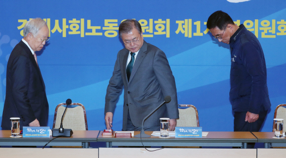 문재인 대통령이 22일 청와대 충무실에서 열린 경제사회노동위원회 첫 회의에서 국민의례를 한 뒤 자리에 앉고 있다. 왼쪽부터 손경식 한국경영자총협회 회장, 문 대통령, 김주영 한국노총위원장. 민주노총은 참석하지 않았다. 2018. 11. 22 도준석 기자 pado@seoul.co.kr