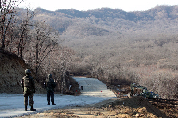 22일 오후  6ㆍ25 전쟁 당시 최대 격전지였던 경기도 연천  화살머리고지에서 남북이 비무장지대(DMZ) 안에서 아직까지 수습하지 못한 6ㆍ25 전쟁 전사자 유해를 공동으로 발굴하는 사업을 위한 남북공동 도로개설 작업 가운데 우리측 지역의 도로공사 현장을 국방부가 공개 했다. 남측 병력이 군사분계선(MDL 도로에 쇄석이 깔려있는 끝 지점) 바로 앞에서 경계를 서고 있다. 남북은 지난 9월19일 체결한 군사합의서에서 원활하게 유해를 발굴하기 위해 12? 폭의 도로를 개설하고 군사분계선에서 연결한다고 합의 했었다. 2018. 11. 22 연천=사진공동취재단