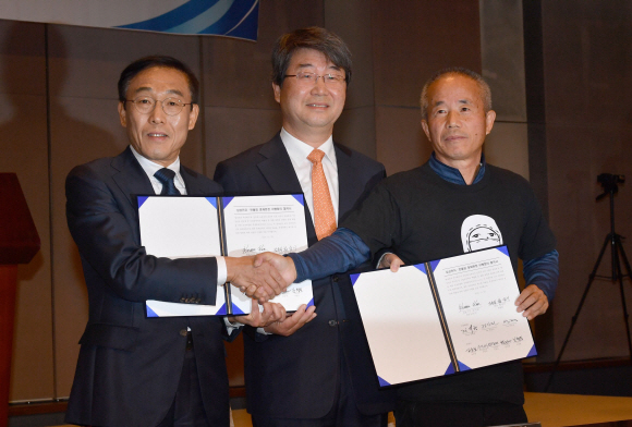 23일 오전 서울 중구 프레스센터에서 열린 삼성전자-반올림 중재판정 이행합의 협약식에서 삼성전자 김기남 대표이사(왼쪽부터), 김지형 조정위원장, 반올림 황상기 대표가 협약서에 서명한 후 기념촬영을 하고 있다. 2018.11.23 박지환기자 popocar@seoul.co.kr