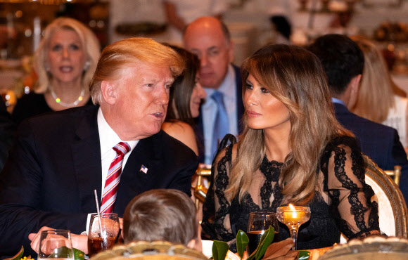 도널드 트럼프 미국 대통령과 부인 멜라니아 트럼프가 22일(현지시간) 미국 플로리다 팜비치 마라라고 리조트에서 이야기를 하며 추수감사절 저녁식사를 하고 있다. AFP 연합뉴스