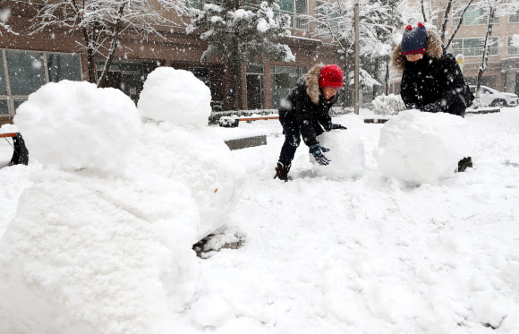 강원 내륙과 산지를 중심으로 대설주의보가 발효 중인 24일 오전 강원 춘천시의 한 아파트 단지 내 놀이터에서 어린이들이 눈사람을 만들고 있다. 2018.11.24  연합뉴스
