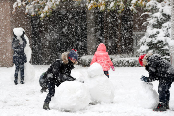 강원 내륙과 산지를 중심으로 대설주의보가 발효 중인 24일 오전 강원 춘천시의 한 아파트 단지 내 놀이터에서 어린이들이 눈사람을 만들고 있다. 2018.11.24  연합뉴스