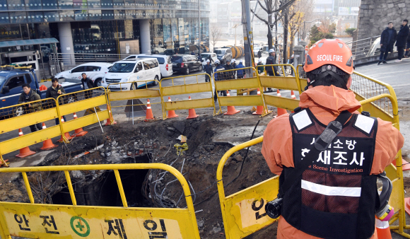 25일 전날 화재가 발생한 서울 충정로 KT 아현빌딩 앞에 화재진압을 위해 파놓은 구덩이를 화재조사반이 촬영을 하고  있다,  2018.11.25 <br>정연호 기자tpgod@seoul.co.kr