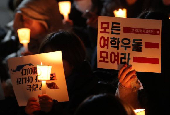 지난 21일 서울 중구 동국대 경영관에서 열린 여학생총회 지지 집회에서 참가자들이 촛불을 들고 있다. 동국대는 이날 학생 총투표를 실시해 총여학생회 폐지를 결정했다.  연합뉴스