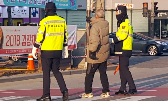 쌀쌀한 날씨를 보인 27일 오전 전북 전주시 덕진광장 부근 횡단보도에서 몸이 불편할 할아버지가 길을 건너자 의경들이 할아버지의 손을 잡고 목적지까지 이동을 돕고 있다. 2018.11.27  연합뉴스