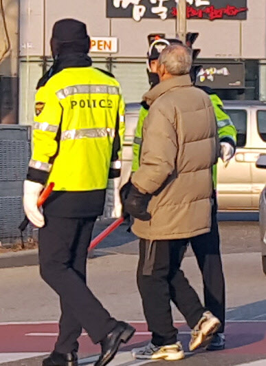 쌀쌀한 날씨를 보인 27일 오전 전북 전주시 덕진광장 부근 횡단보도에서 몸이 불편할 할아버지가 길을 건너자 의경들이 할아버지의 손을 잡고 목적지까지 이동을 돕고 있다. 2018.11.27  연합뉴스