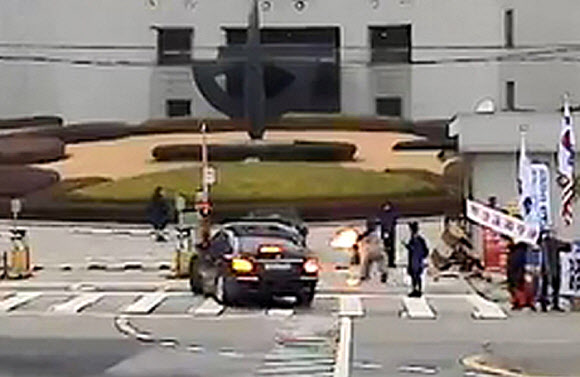 27일 오전 서울 서초구 대법원 앞에서 70대 한 남성이 김명수 대법원장이 타고 있는 출근차량을 향해 화염병을 투척하고 있다. 2018.11.27  김정수씨 제공=연합뉴스