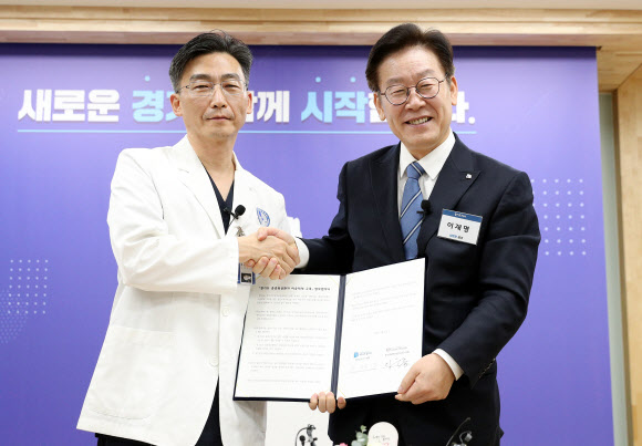 이재명 경기지사(오른쪽)와 경기남부권역외상센터장인 아주대학교 이국종 교수가 27일 도지사 집무실에서 열린 ‘경기도 중증외상환자 이송체계 구축’ 업무 협약식에서 기념촬영을 하고 있다. 2018.11.27  경기도 제공