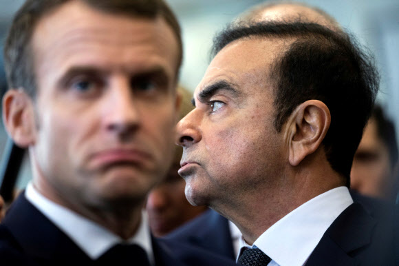 에마뉘엘 마크롱(왼쪽) 프랑스 대통령과 카를로스 곤(오른쪽) 르노 회장이 지난 8일(현지시간) 프랑스 북부 모뵈주의 르노 공장을 둘러보고 있다.  모뷔주 로이터 연합뉴스