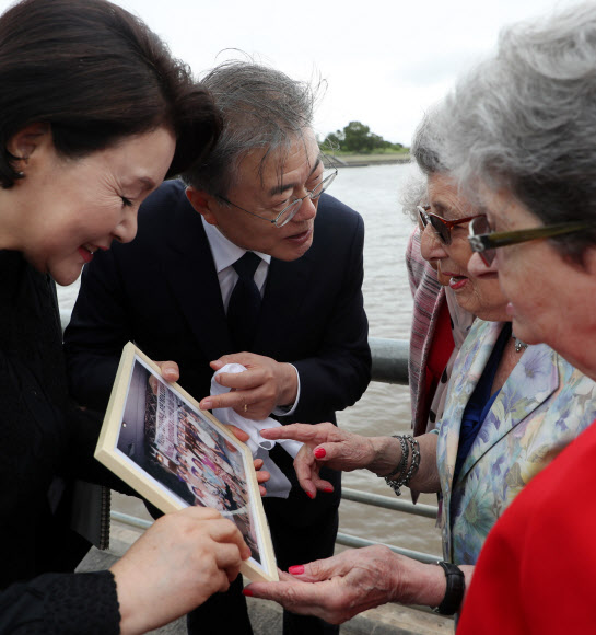 ‘5월 광장 어머니들’에게 한국 방문 당시 사진 전달하는 문 대통령 내외