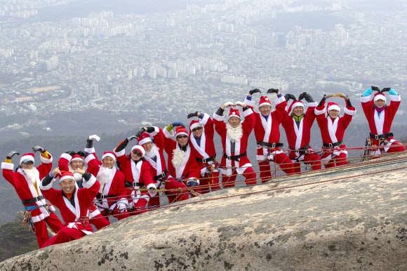 2일 고양 북한산 백운대 정상에서 산타복을 입은 쌩곰등반클럽, 산이좋아 산악회원들이 구세군 자선냄비 행사 발대식을 맞아 포즈를 취하고 있다. 박창용 쌩곰등반클럽회장과 산악회원들은 12월 말까지 매주 토,일 8회에 걸쳐 북한산 일원에서 자선모금 캠페인을 할 계획이다. 2018.12.2  연합뉴스