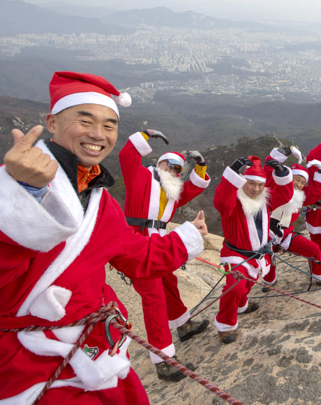 2일 고양 북한산 백운대 정상에서 산타복을 입은 쌩곰등반클럽, 산이좋아 산악회원들이 구세군 자선냄비 행사 발대식을 맞아 포즈를 취하고 있다. 박창용 쌩곰등반클럽회장과 산악회원들은 12월 말까지 매주 토,일 8회에 걸쳐 북한산 일원에서 자선모금 캠페인을 할 계획이다. 2018.12.2  연합뉴스