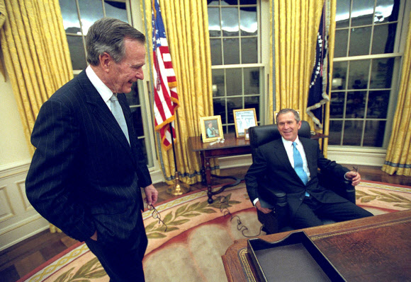 아버지 부시(왼쪽) 전 대통령이 2001년 1월 20일 취임식을 가진 아들 부시 대통령과 대화를 나누고 있다.  로이터 연합뉴스 