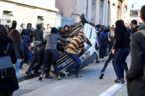 시위하는 고등학생들이 6일(현지시간) 프랑스 남부 마르세이유에서 정부 교육 개혁에 반대하며 차량을 뒤집고 있다.  AFP 연합뉴스