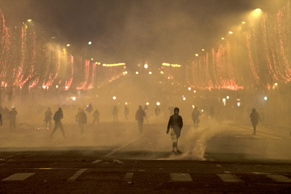 Yellow vest protesters stand amid smoke during a demonstration in Paris, France, 08 December 2018. Police in Paris is preparing for another weekend of protests of the so-called ‘gilets jaunes’ (yellow vests) protest movement. Recent demonstrations of the movement, which reportedly has no political affiliation, had turned violent and caused authorities to close some landmark sites in Paris this weekend. 2018.12.09 EPA 연합뉴스