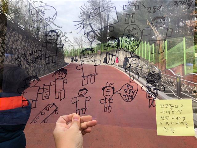 지난 6일 서울 강북구 미아동 삼양초등학교 4학년 5반 학생들이 새로 교문을 만들었을 때 나타나게 될 변화를 직접 그려 교문 앞에서 들어 보이고 있다.  삼양초 제공