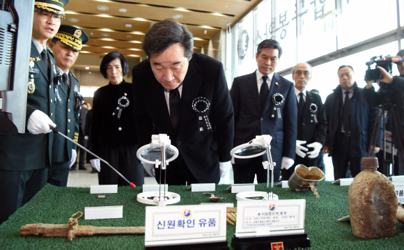 이낙연 국무총리가 12일 서울 동작구 국립서울현충원에서 거행된  6.25전쟁 국군전사자 유해 365위에 대한 합동 봉안식에 참석, 행사장에 전시된 신원확인 유품을 둘러보고 있다. 이날 봉안식은 유해발굴 추진경과 보고와 종교의식, 헌화와 분향, 영현봉송 순으로 진행됐으며, 이낙연 국무총리를 비롯해 정경두 국방부 장관, 보훈단체대표 등 350여명이 참석했다.2018.12.12. 이종원 선임기자 jongwon@seoul.co.kr