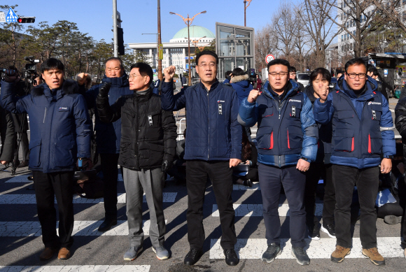 12일 서울 국회앞 국민은행에서 열린 카카오택시 카풀반대 집회에 참석한 택시업계 관계자들이 정부의 책임있는 자세를 촉구하며 구호를 외치고 있다. 2018.12.12 박지환기자 popocar@seoul.co.kr