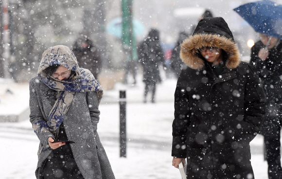 중부지역에 눈이 내린 13일 서울 중구 태평로에서 시민들이 잔뜩 웅크린 채 걷고 있다. 2018. 12. 13  정연호 기자 tpgod@seoul.co.kr