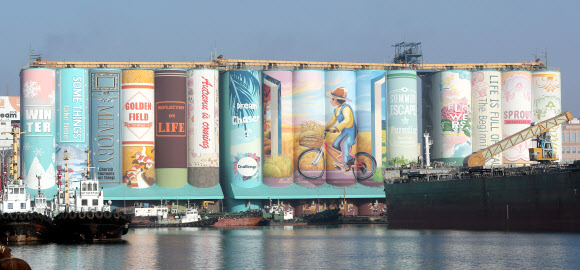 17일 오전 인천시 중구 인천항 7부두 내 사일로(Silo·곡식저장시설) 외벽에 벽화가 그려져 있다. 이 벽화는 높이 48m, 길이 168m, 폭 31.5m 규모로 시간의 흐름을 상징하는 봄·여름·가을·겨울 북 커버 장식이 그려졌고 성장 과정을 의미하는 문구가 16권의 책 제목으로 디자인됐다. 이 벽화는 ‘세계에서 가장 큰 야외벽화’로 기네스북에 이름을 올렸다. 2018.12.17  연합뉴스