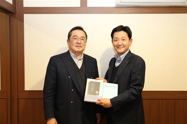 구자열(왼쪽) LS그룹 회장이 14일 LS용산타워에서 신규 임원이 된 박석원 LS산전 이사에게 책을 선물하고 있다.  LS그룹 제공