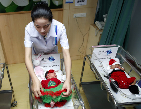 신생아들이 21일(현지시간) 태국 방콕의 Paolo Memorial Hospital Chokchai 4에서 크리스마스 시즌을 맞아 산타클로스 의상을 입고 있다. 병원에서는 크리스마스 시즌을 축하하는 배달 패키지의 일환으로 산타클로스 복장을 신생아에게 제공하고 있다. EPA 연합뉴스