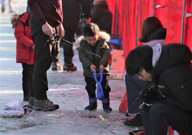 제12회 평창송어축제가 개막한 22일 축제가 열리고 있는 강원 평창군 진부면 오대천 축제장을 찾은 관광객들이 얼음 낚시를 즐기고 있다. 축제는 이날 개막과 함께 동시에 5000명을 수용할 수 있는 얼음낚시터가 모두 매진되는 등 인산인해를 이뤘다.2018.12.22 뉴스1