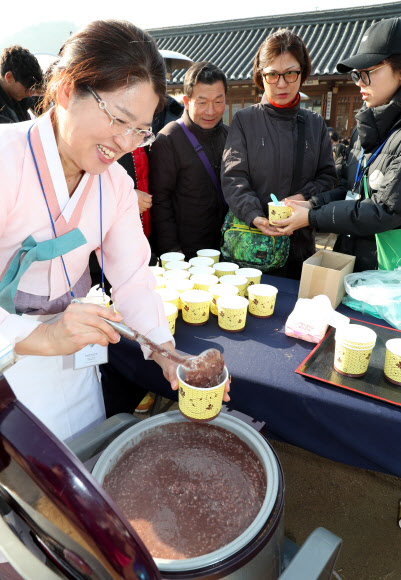 22일 동지를 맞아 열린 서울 남산골한옥마을 세시절기행사 ‘동지첨치’에 참가한 시민들이 팥죽을 받고 있다. 2018.12.22  연합뉴스